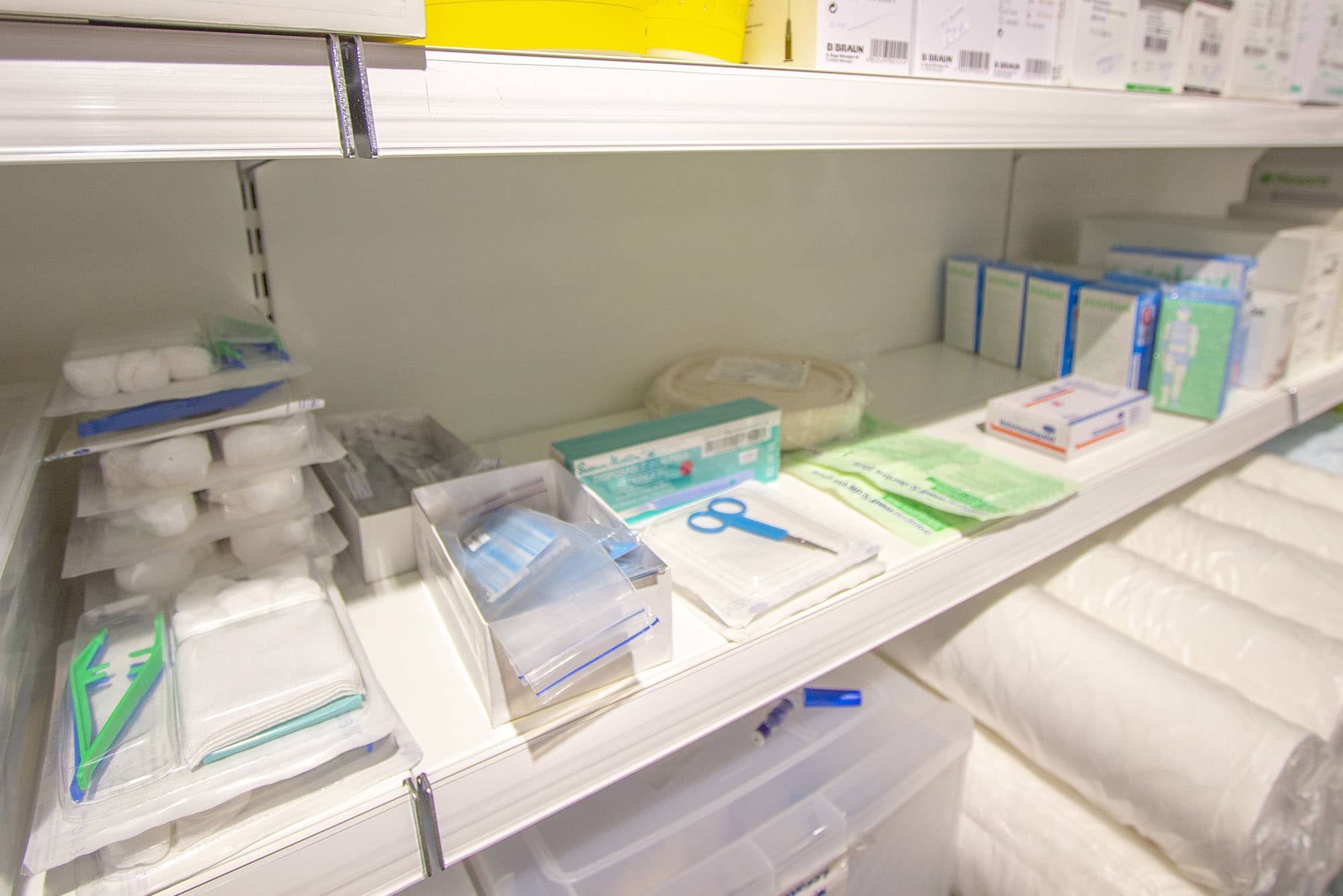 Diverso materiale ospedaliero al dettaglio esposto su ripiani della farmacia